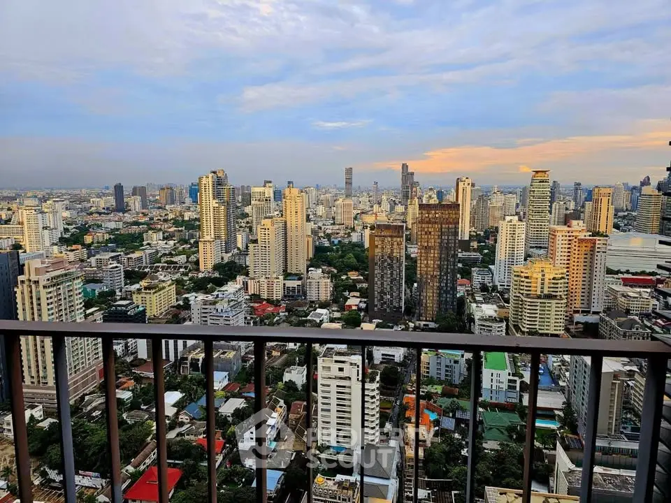 Stunning cityscape view from a high-rise balcony showcasing urban skyline at sunset.