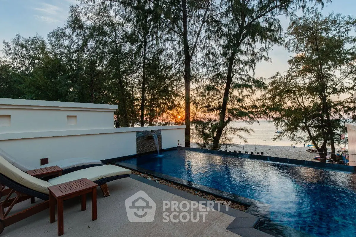 Luxurious beachfront pool with sunset view and elegant lounge chairs
