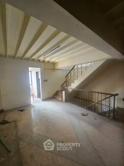 Spacious building entrance with elegant staircase and natural lighting