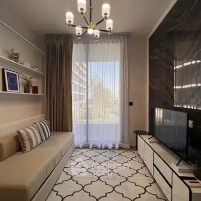 Modern living room with elegant chandelier, stylish sofa, and large TV, featuring floor-to-ceiling window with sheer curtains.