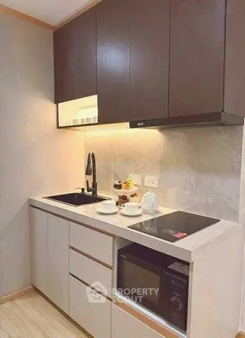 Modern compact kitchen with sleek cabinets and built-in appliances