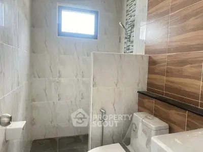 Modern bathroom with marble tiles and wooden accents