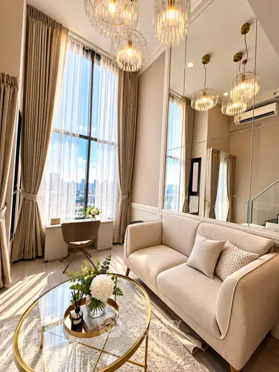 Luxurious high-ceiling living room with elegant decor and stunning city view.