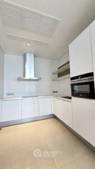 Modern kitchen with sleek white cabinetry and built-in appliances