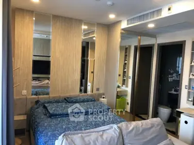 Modern bedroom with stylish decor and ensuite bathroom in a contemporary apartment.