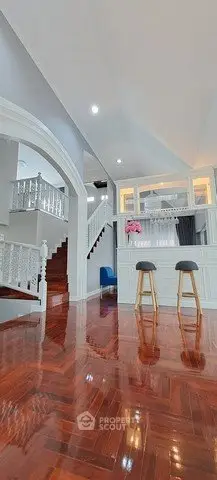 Elegant interior with polished wooden floors and stylish staircase in a modern home.