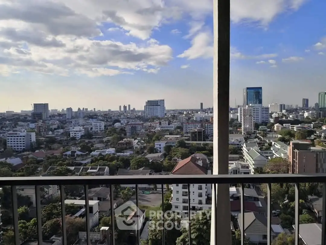 Stunning cityscape view from a high-rise balcony with clear skies and urban skyline.