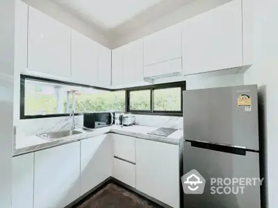 Modern kitchen with sleek white cabinets and stainless steel appliances