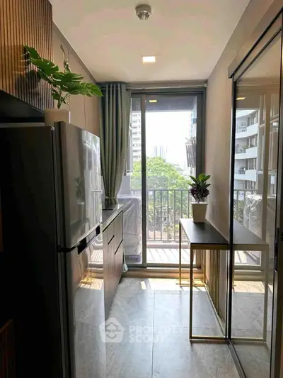 Modern kitchen with balcony view, sleek appliances, and stylish decor in urban apartment.