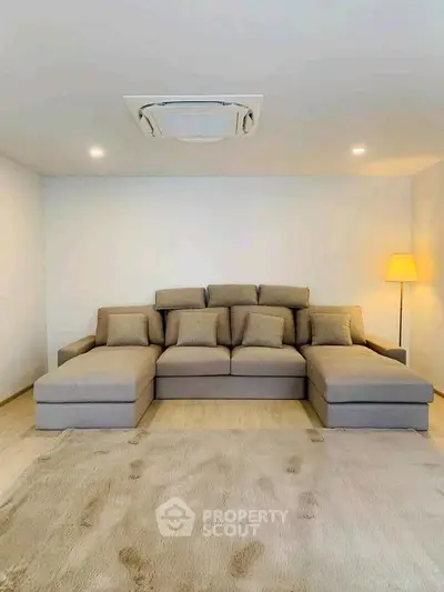 Spacious living room with modern sectional sofa and cozy lighting