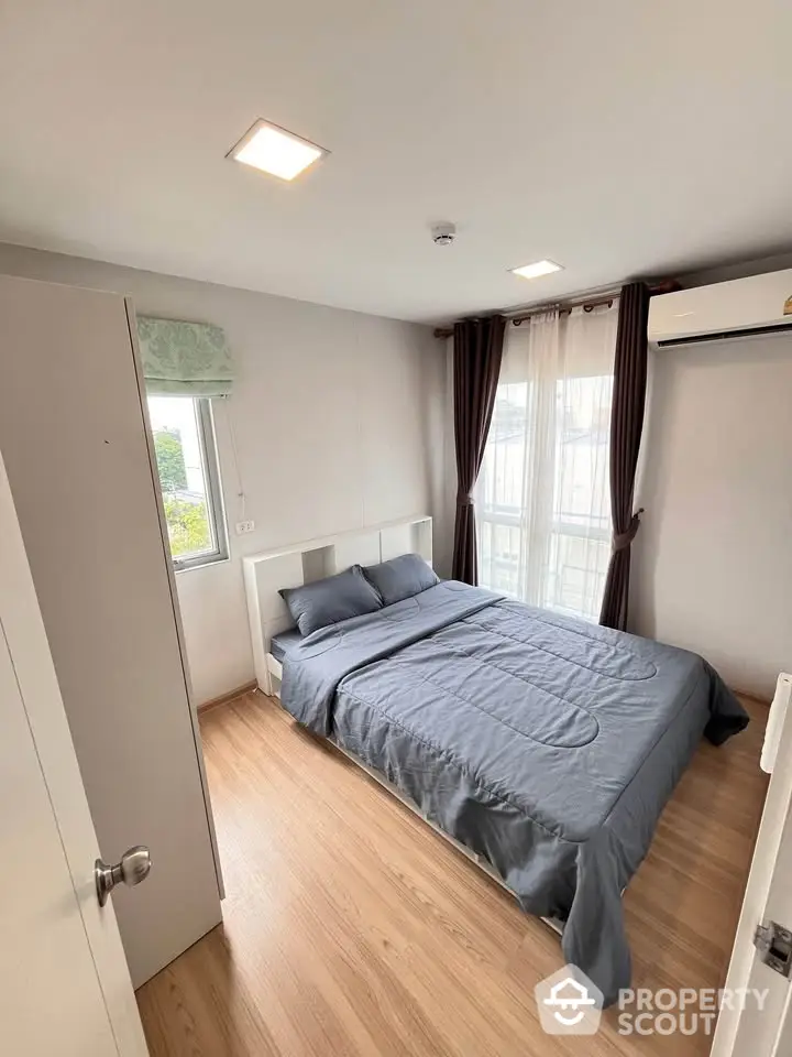 Modern bedroom with wooden flooring and natural light