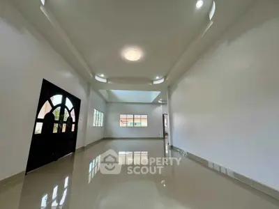 Spacious modern living room with glossy tiled floors and elegant ceiling lights.