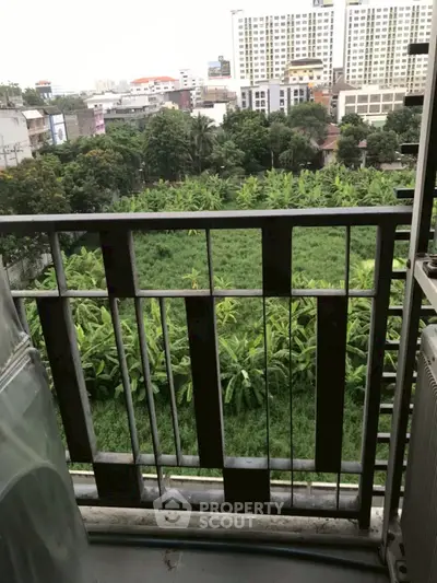 Scenic balcony view overlooking lush green landscape and city skyline.