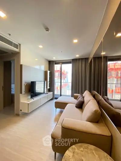Modern living room with large windows and stylish furniture in a high-rise apartment.