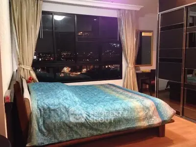 Cozy bedroom with city view and elegant decor, featuring large windows and stylish furnishings.