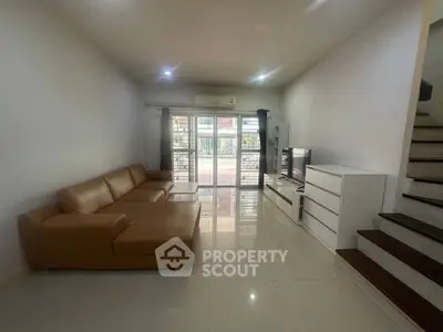 Spacious living room with modern brown leather sofa and sleek entertainment center