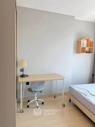 Modern bedroom with minimalist desk and chair, perfect for a cozy home office setup.