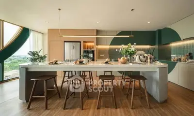 Spacious modern kitchen with island seating and stylish decor, featuring open layout and large windows.