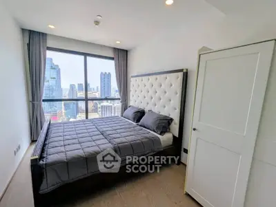 Luxurious bedroom with stunning city view and elegant decor in modern high-rise apartment.