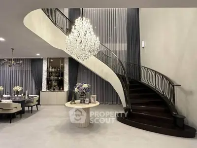Luxurious living room with elegant staircase and chandelier