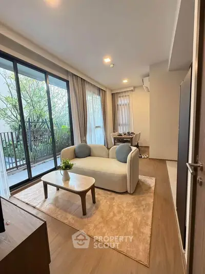 Modern living room with cozy sofa and large windows overlooking a lush garden.