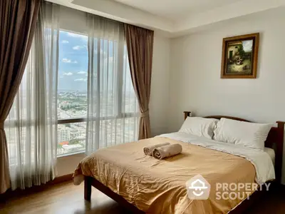 Elegant bedroom with polished wooden floors and large windows offering a panoramic city view, adorned with tasteful curtains and artwork.