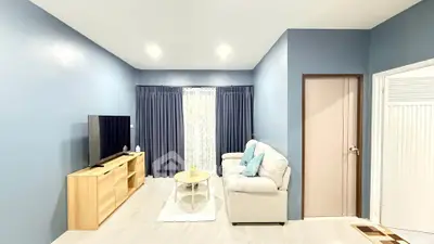 Modern living room with sleek design, featuring a cozy sofa, stylish TV stand, and elegant curtains.