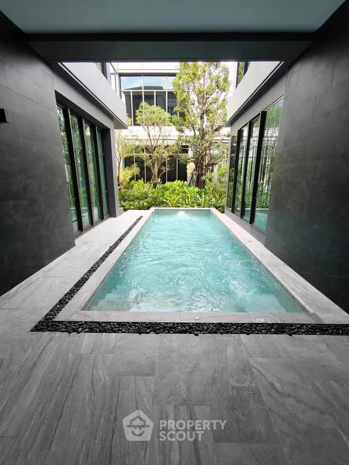 Luxurious private pool with modern design and lush greenery in a contemporary home setting.