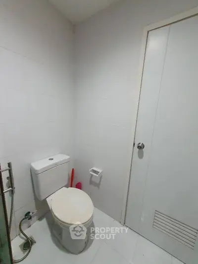 Modern minimalist bathroom with white tiles and sleek fixtures.