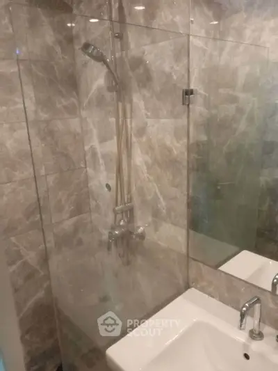 Modern bathroom with glass shower and marble tiles