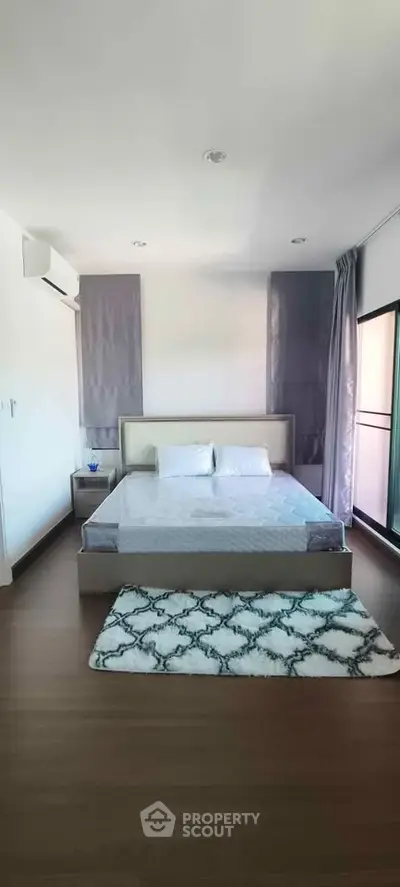 Spacious bedroom with modern decor and large window for natural light