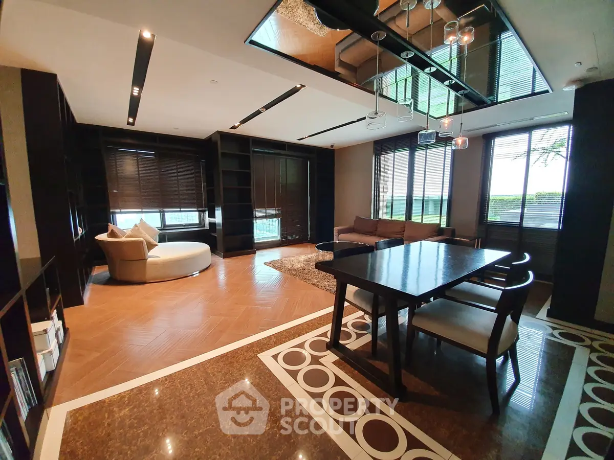 Luxurious modern living room with elegant furniture and large windows offering natural light.