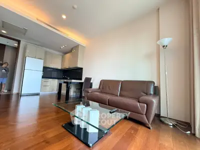 Modern living room with sleek furniture and open kitchen layout in a stylish apartment.