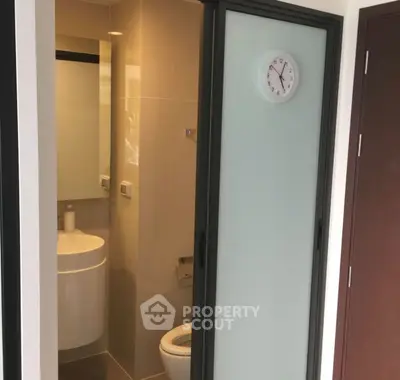 Compact bathroom with sliding door and modern fixtures.