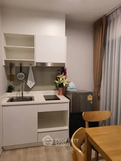 Modern kitchen with sleek white cabinets and cozy dining area