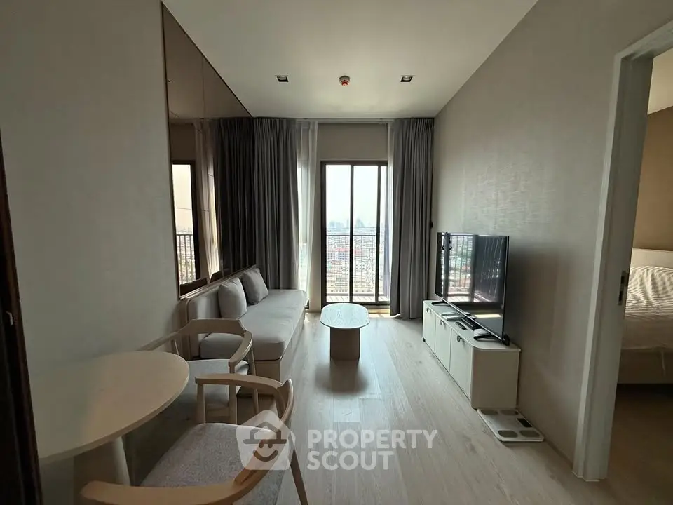 Modern living room with city view, featuring cozy seating and a sleek TV setup.