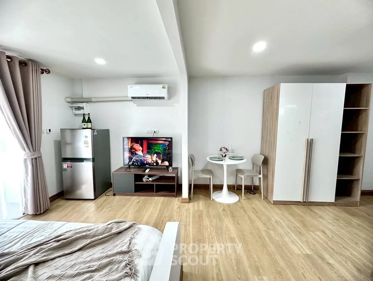 Modern studio apartment with stylish furniture and open layout, featuring a cozy living area and dining space.