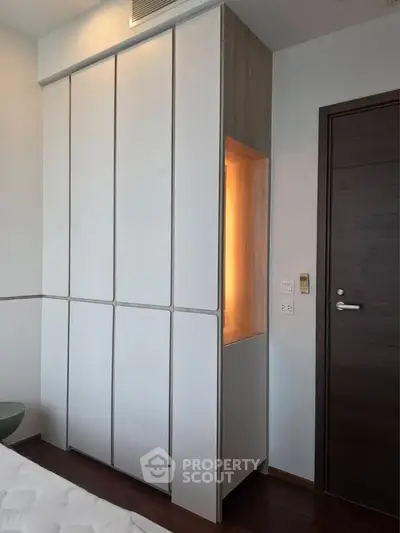 Modern bedroom with sleek built-in wardrobe and wooden door