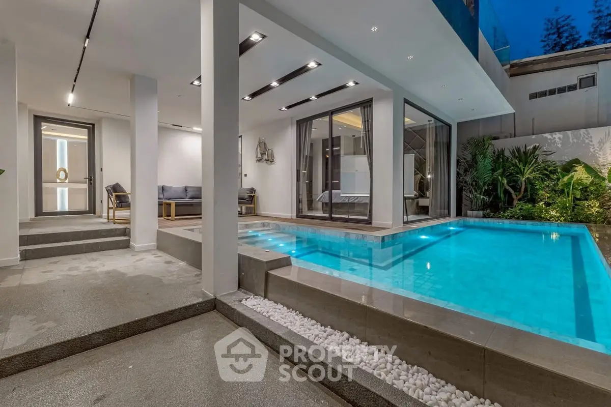 Luxurious modern home with private pool and elegant outdoor seating area.