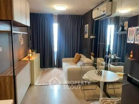 Modern living room with cozy sofa, dining table, and stylish decor in a compact apartment.
