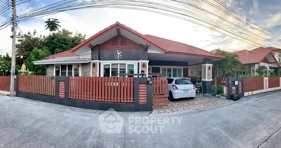 Charming single-story house with red roof, spacious driveway, and modern fence in a serene neighborhood.
