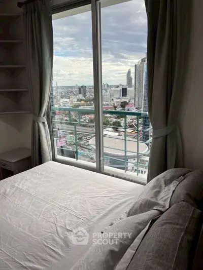 Stunning city view from a cozy bedroom with large window and elegant curtains.