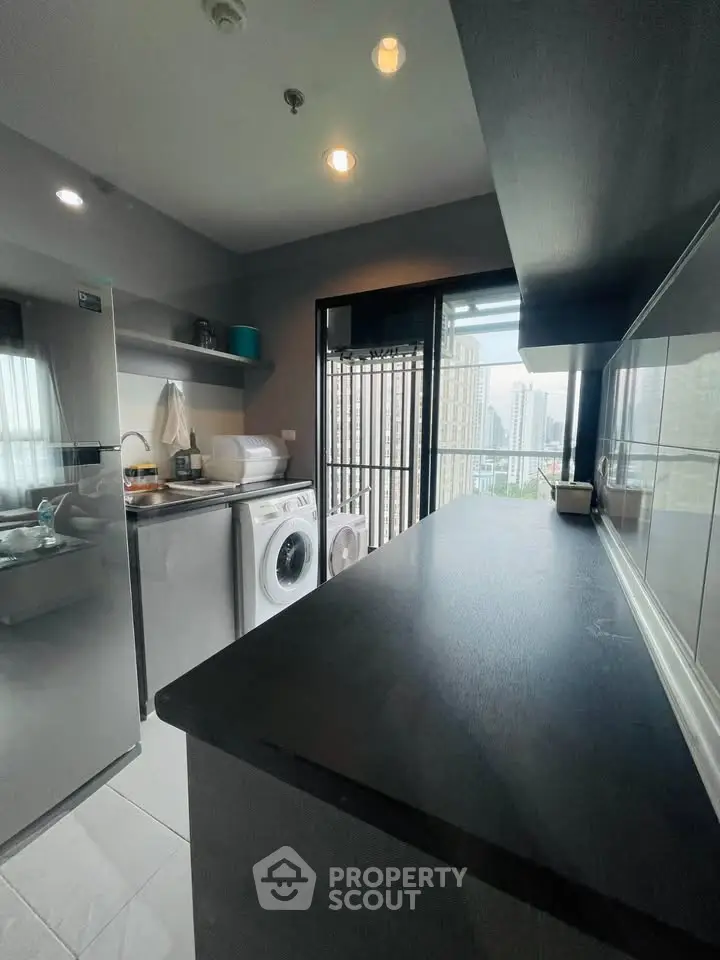Modern kitchen with washing machine and city view from balcony