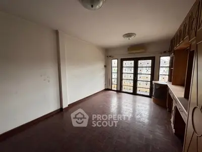 Spacious empty room with wooden flooring and built-in cabinets, ideal for customization.