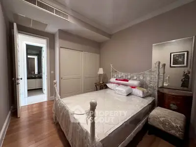 Charming bedroom with elegant decor and ensuite bathroom in a cozy real estate property.