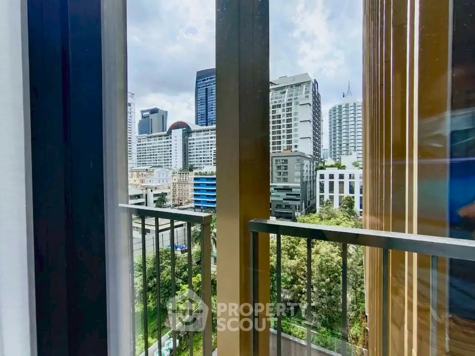 Stunning cityscape view from modern apartment balcony with lush greenery.