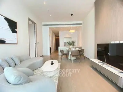 Modern open-plan living room with stylish furniture and dining area, perfect for entertaining.