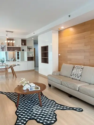 Modern living room with stylish decor and open layout, featuring a cozy sofa and elegant dining area.