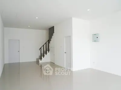 Spacious minimalist interior with sleek staircase and glossy tiled floor, perfect for modern living.