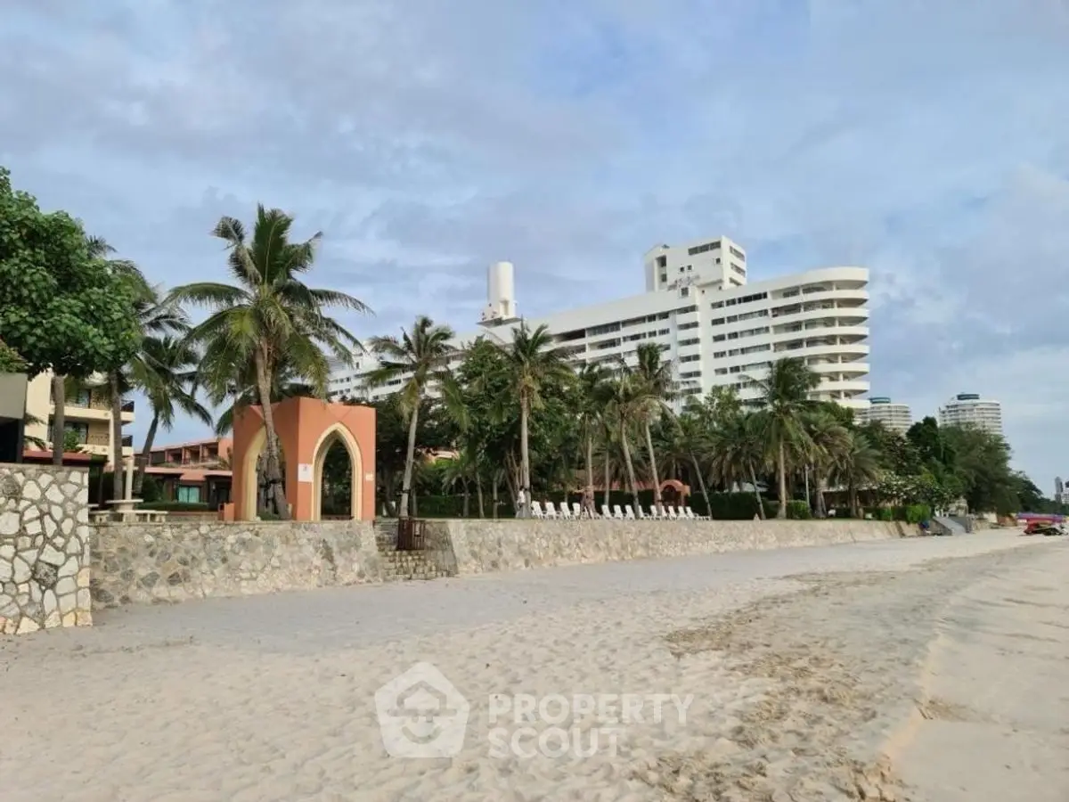 Stunning beachfront property with modern architecture and lush palm trees, perfect for luxury living.